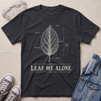 A black botanical t-shirt featuring a vintage labeled leaf anatomy illustration with the pun “Leaf Me Alone” in bold retro typography.
