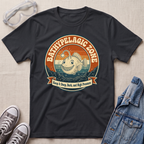 A black graphic t-shirt laid flat on a light beige textured background, styled with a pair of clear safety goggles, gray sneakers, and a blue denim jacket. The t-shirt features a retro-style circular graphic of a smiling fish in the bathypelagic zone with the text 'BATHYPELAGIC ZONE' and 'Keep it Deep, Dark, and High Pressure'.