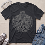 A black botanical t-shirt featuring an intricate tree root illustration with the pun “I’m Rooting For You” in bold vintage-style lettering.