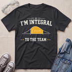 A navy blue graphic t-shirt laid flat on a beige fabric background, styled with safety goggles, gray sneakers, and a denim jacket. The t-shirt features a white graphic that reads 'I'M INTEGRAL TO THE TEAM' with a yellow integral curve diagram.