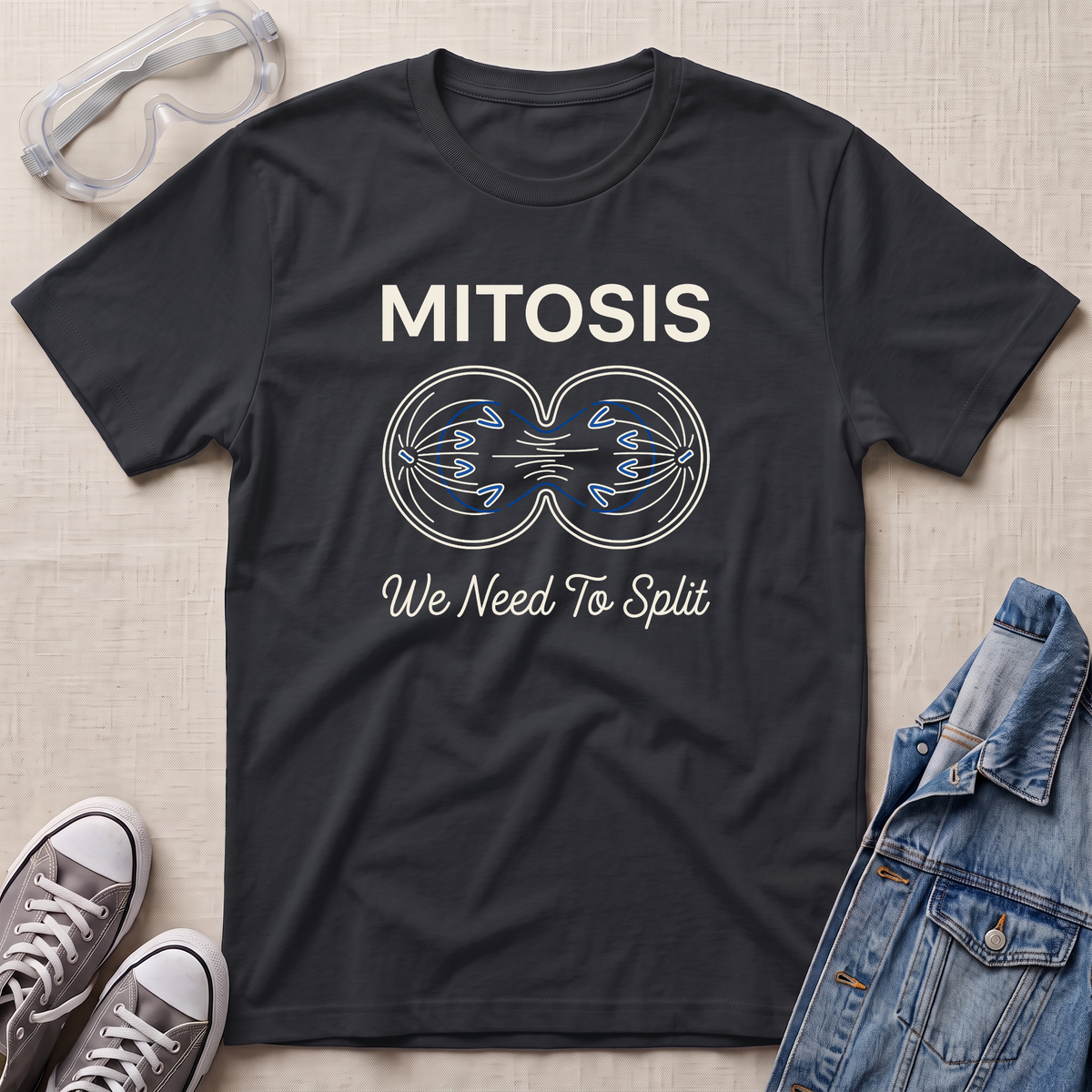A black science t-shirt featuring a mitosis cell division diagram with “MITOSIS – We Need To Split” text, styled with lab goggles, sneakers, and a denim jacket.