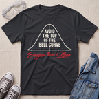 A black graphic t-shirt laid flat on a light beige textured background, styled with safety goggles, gray sneakers, and a denim jacket. The t-shirt features a white bell curve graphic with the text 'AVOID THE TOP OF THE BELL CURVE' and red script text reading 'Everyone there is Mean'.