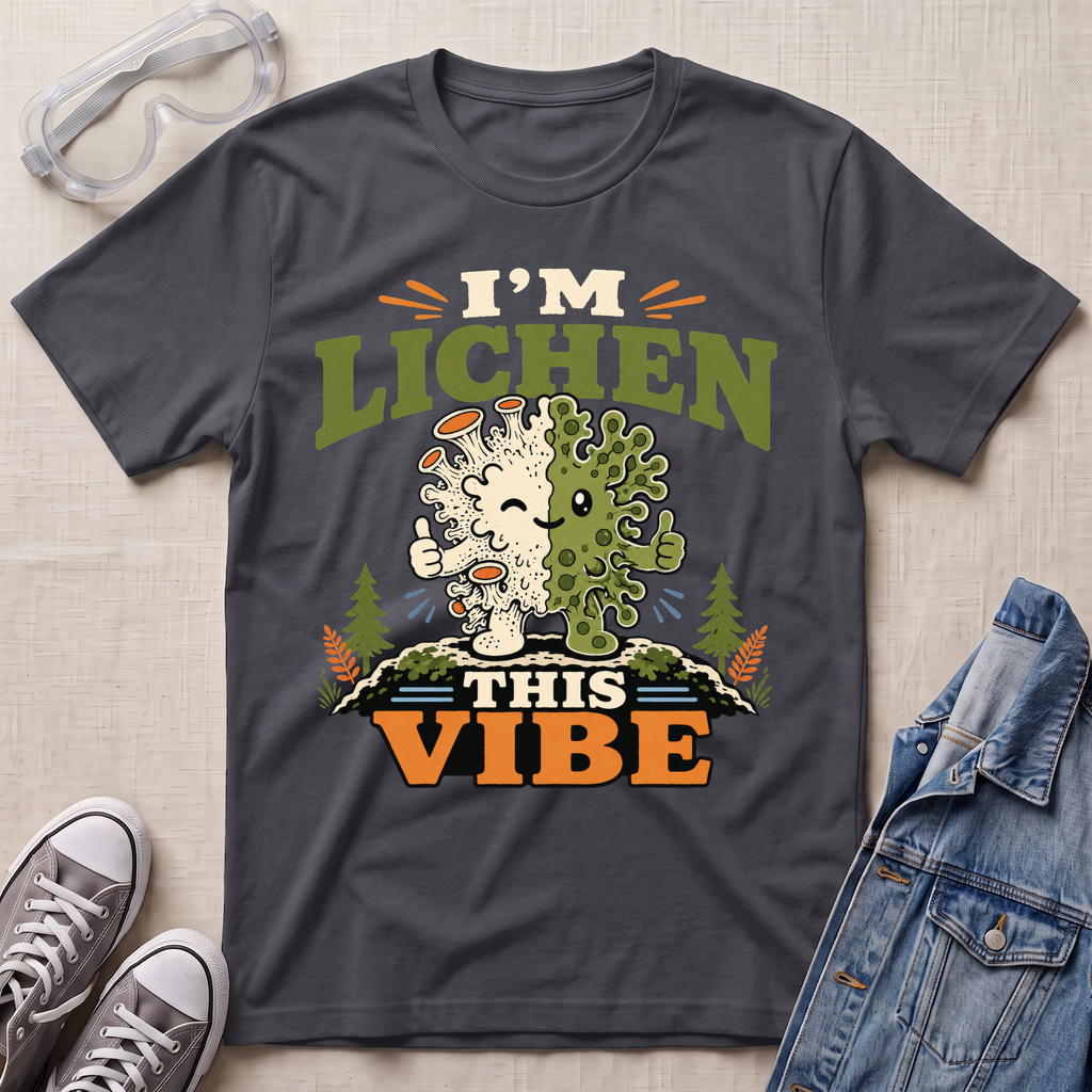 A dark charcoal grey science t-shirt featuring a cute lichen character with the pun “I’m Lichen This Vibe,” surrounded by retro botanical and nature-inspired accents.