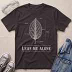 A dark chocolate brown botanical t-shirt featuring a vintage labeled leaf anatomy illustration with the pun “Leaf Me Alone” in bold retro typography.