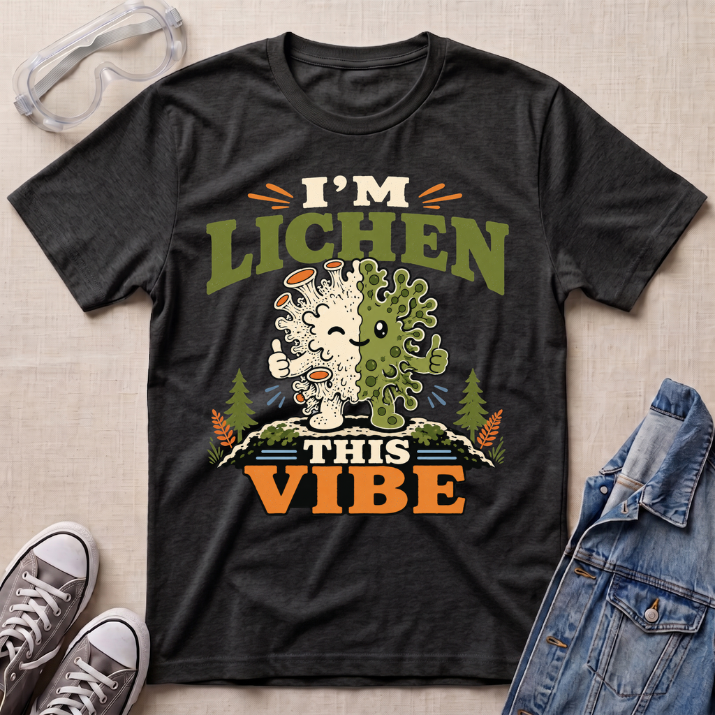 A dark heather grey science t-shirt featuring a cute lichen character with the pun “I’m Lichen This Vibe,” surrounded by retro botanical and nature-inspired accents.