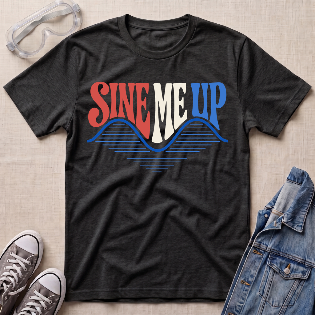 A dark charcoal gray graphic t-shirt laid flat on a beige textured background, surrounded by styling props including safety goggles, gray sneakers, and a denim jacket. The t-shirt features a retro-style graphic reading 'SINE ME UP' in red, white, and blue, with a wavy blue line pattern underneath.