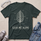 A dark forest green botanical t-shirt featuring a vintage labeled leaf anatomy illustration with the pun “Leaf Me Alone” in bold retro typography.