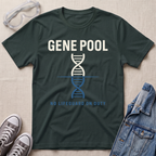A forest green graphic t-shirt laid flat on a light beige textured background, surrounded by lifestyle props including safety goggles, gray sneakers, and a denim jacket. The t-shirt features a white and blue DNA double helix graphic with the text 'GENE POOL' and 'NO LIFEGUARD ON DUTY'.