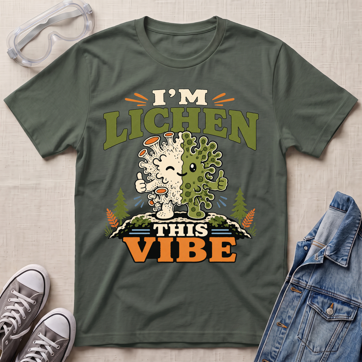 A military green science t-shirt featuring a cute lichen character with the pun “I’m Lichen This Vibe,” surrounded by retro botanical and nature-inspired accents.