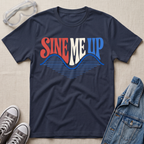 A navy blue graphic t-shirt laid flat on a textured beige fabric background, styled with safety goggles, gray sneakers, and a denim jacket. The t-shirt features a retro-style graphic reading 'SINE ME UP' in red, white, and blue, with a blue soundwave design underneath.