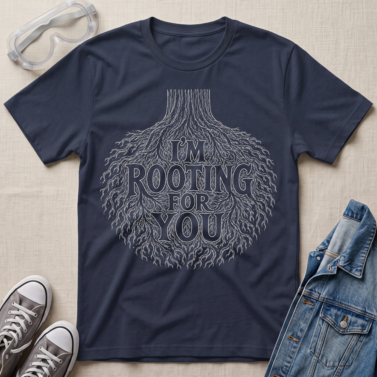 A navy blue botanical t-shirt featuring an intricate tree root illustration with the pun “I’m Rooting For You” in bold vintage-style lettering.