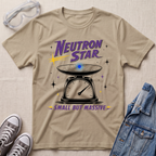 A sand beige graphic t-shirt featuring a 'Neutron Star' design with a scale and star theme, styled in a flat-lay with safety goggles, sneakers, and a denim jacket on a textured beige background.