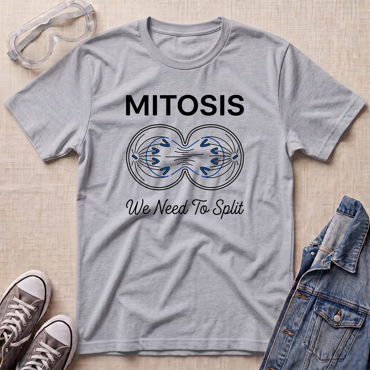 A heather grey science t-shirt featuring a mitosis cell division diagram with “MITOSIS – We Need To Split” text, styled with lab goggles, sneakers, and a denim jacket.