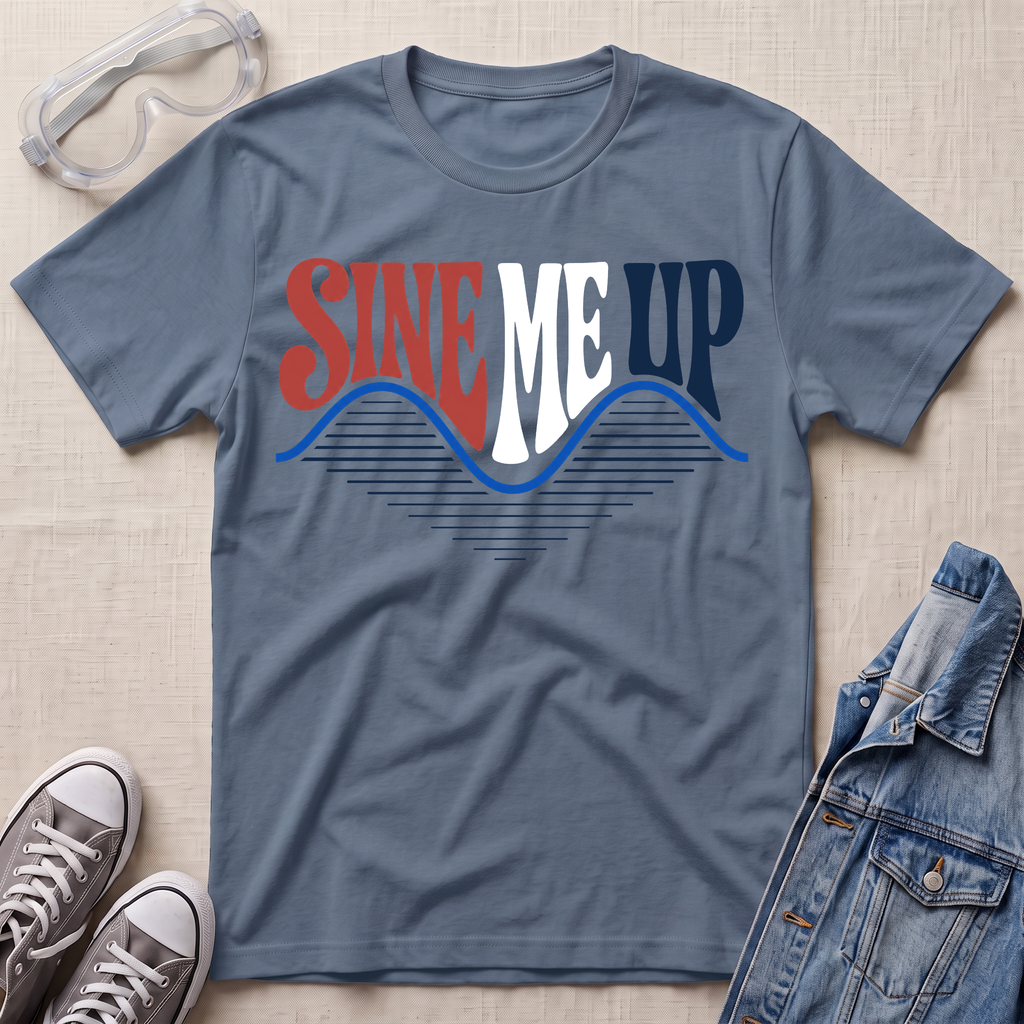 A slate blue graphic t-shirt laid flat on a light beige textured background, styled with safety goggles, gray sneakers, and a denim jacket. The t-shirt features a retro-style graphic reading 'SINE ME UP' in red, white, and blue, with a wavy blue line underneath.