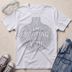 A white botanical t-shirt featuring an intricate tree root illustration with the pun “I’m Rooting For You” in bold vintage-style lettering.