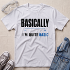 A white graphic t-shirt laid flat on a light beige textured background, styled with safety goggles, gray sneakers, and a denim jacket. The t-shirt features a black and blue graphic that reads 'BASICALLY I'M QUITE BASIC' with a simple line diagram.