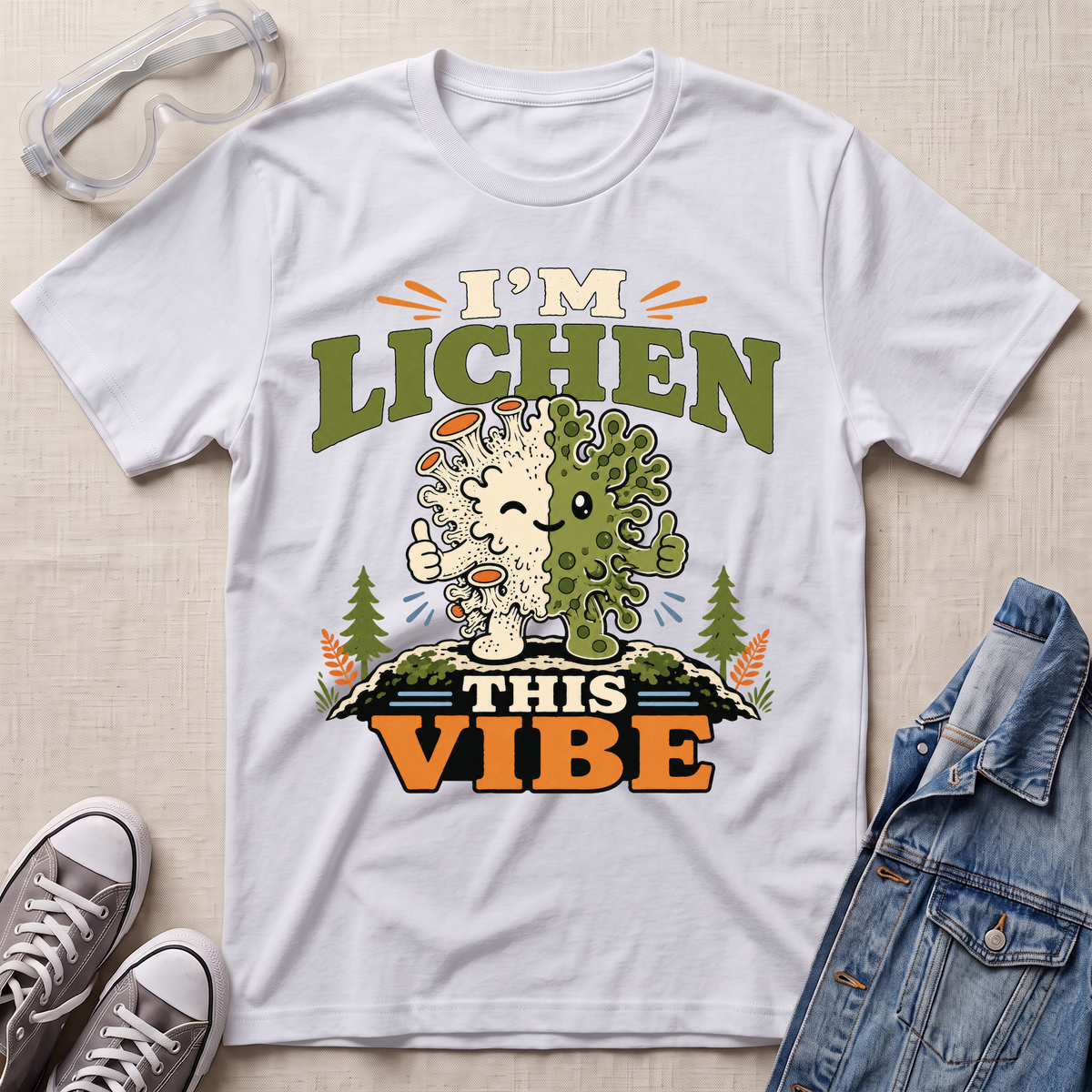 A white science t-shirt featuring a cute lichen character with the pun “I’m Lichen This Vibe,” surrounded by retro botanical and nature-inspired accents.